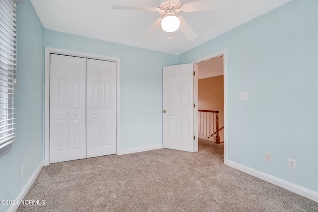 unfurnished bedroom with a closet, ceiling fan, and light colored carpet