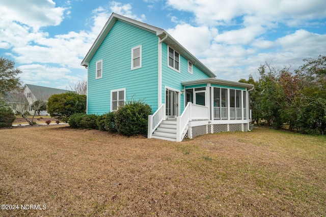 view of side of property with a sunroom and a yard