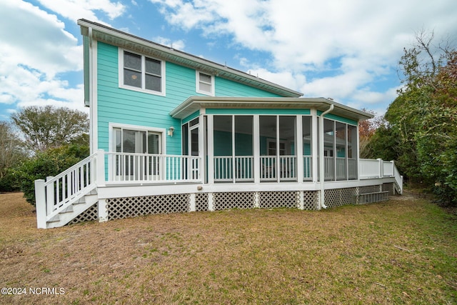 rear view of house featuring a sunroom and a yard