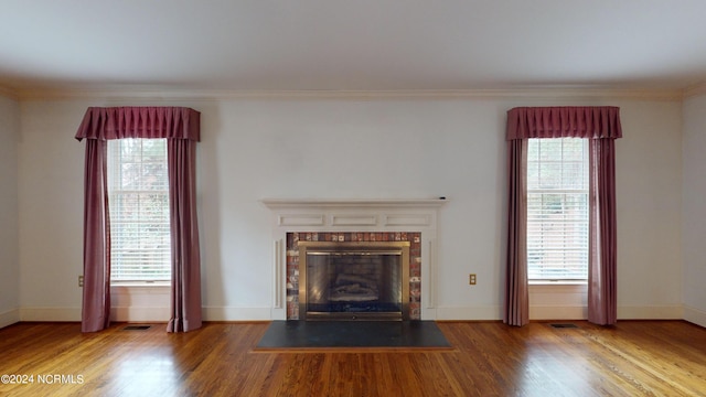 unfurnished living room featuring crown molding, dark hardwood / wood-style flooring, and a wealth of natural light