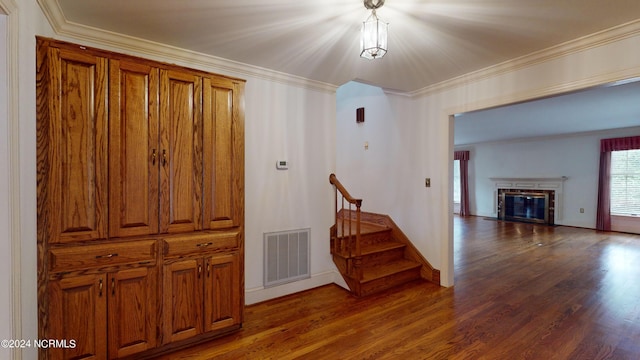 hall with dark wood-type flooring and ornamental molding