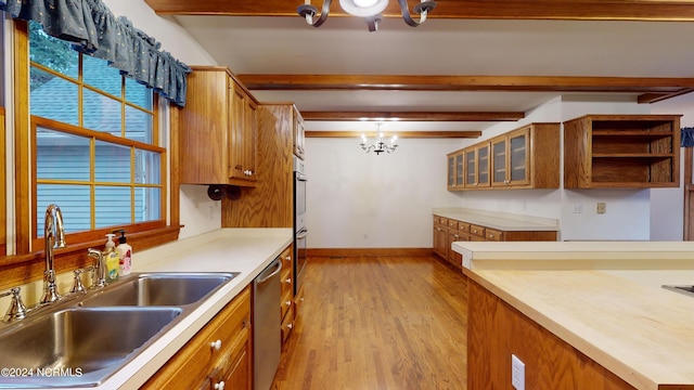 kitchen with an inviting chandelier, pendant lighting, light wood-type flooring, beam ceiling, and sink