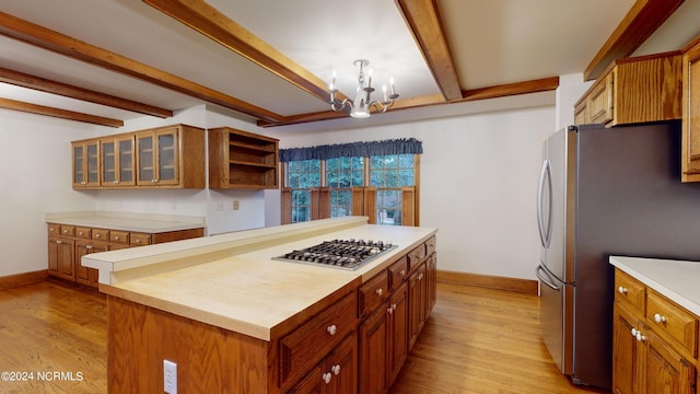 kitchen with appliances with stainless steel finishes, a chandelier, light hardwood / wood-style flooring, wooden counters, and beam ceiling