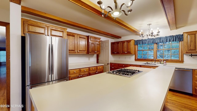 kitchen featuring sink, light hardwood / wood-style flooring, beamed ceiling, stainless steel appliances, and a notable chandelier