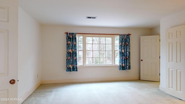 unfurnished room featuring light carpet