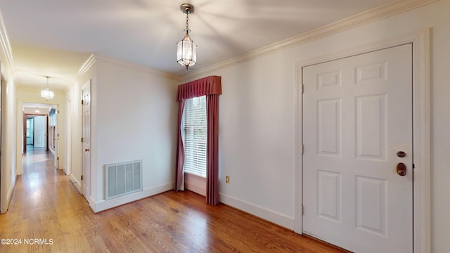 entrance foyer featuring light hardwood / wood-style floors and ornamental molding