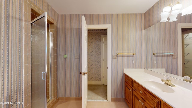 bathroom with vanity, tile floors, and a shower with door