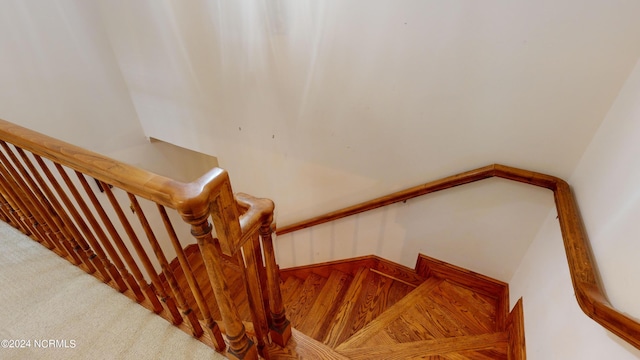 stairway featuring light colored carpet