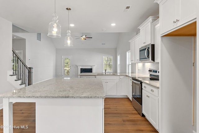 kitchen with pendant lighting, white cabinetry, sink, kitchen peninsula, and stainless steel appliances