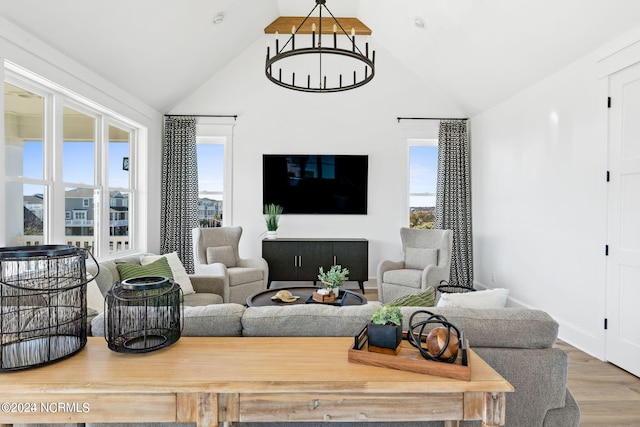 living room with hardwood / wood-style floors, vaulted ceiling, and a healthy amount of sunlight