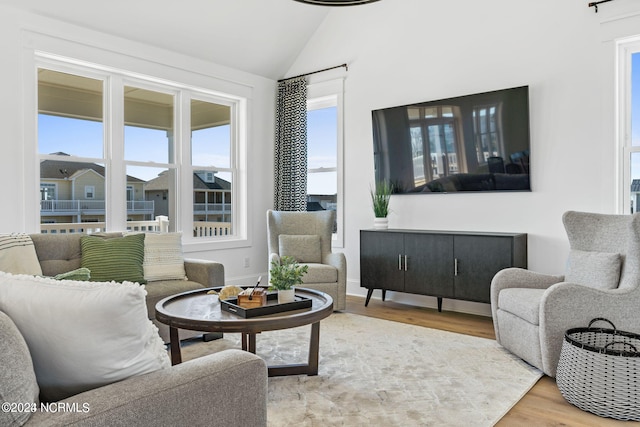 living room featuring light hardwood / wood-style flooring and vaulted ceiling