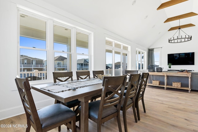 dining space with a chandelier, light hardwood / wood-style flooring, high vaulted ceiling, and beamed ceiling