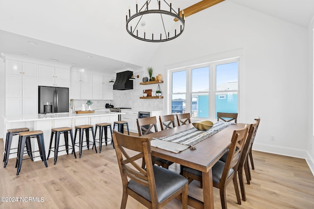 dining space featuring vaulted ceiling, light wood-type flooring, and an inviting chandelier