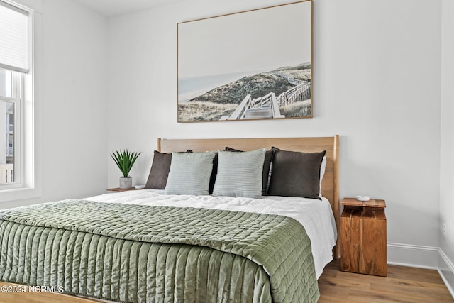 bedroom featuring multiple windows and light wood-type flooring