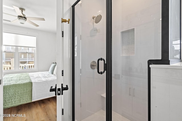 bathroom with a shower with door, ceiling fan, and hardwood / wood-style flooring