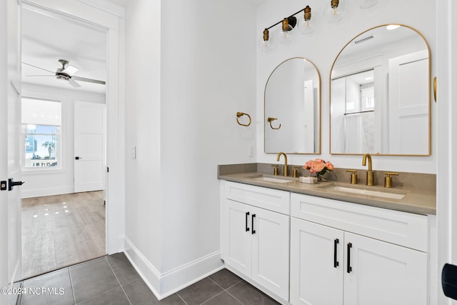 bathroom featuring ceiling fan, double vanity, and wood-type flooring