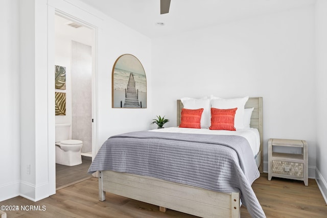 bedroom featuring ceiling fan, ensuite bathroom, and dark wood-type flooring