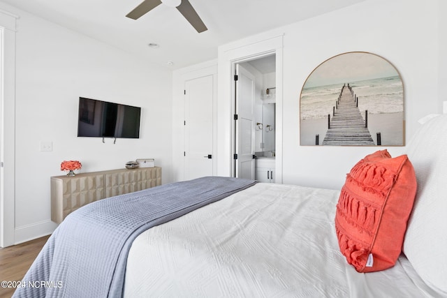 bedroom with connected bathroom, ceiling fan, and dark wood-type flooring