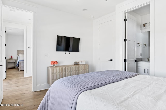 bedroom featuring ensuite bathroom and light hardwood / wood-style floors