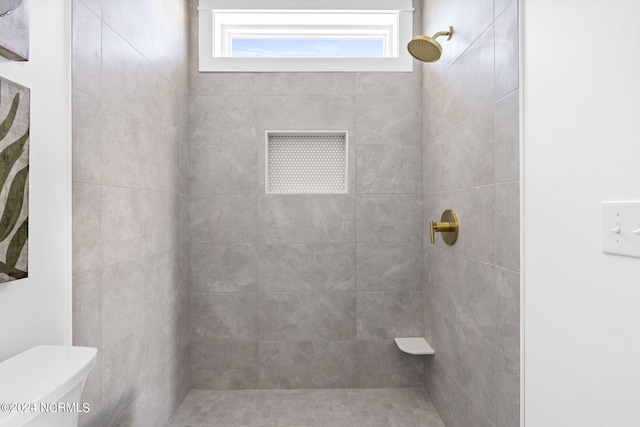 bathroom featuring toilet and tiled shower