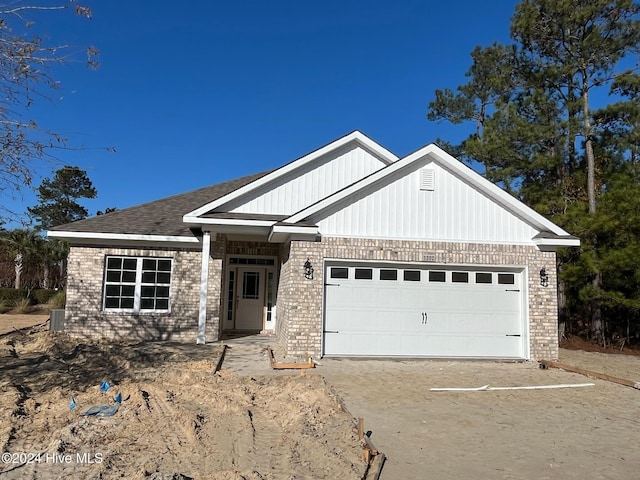 view of front of property featuring driveway, brick siding, and an attached garage