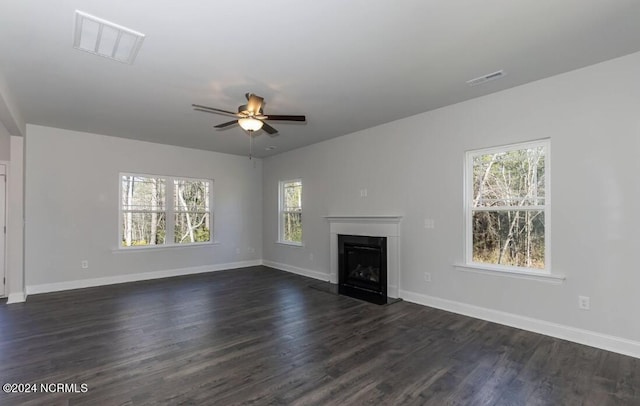 unfurnished living room featuring dark wood-style floors, a fireplace, visible vents, and baseboards