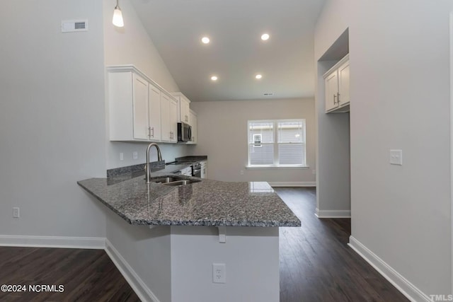 kitchen featuring appliances with stainless steel finishes, white cabinetry, a peninsula, and a breakfast bar area