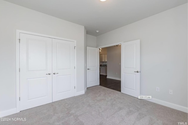 unfurnished bedroom featuring carpet, baseboards, and a closet