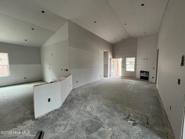 unfurnished living room featuring high vaulted ceiling