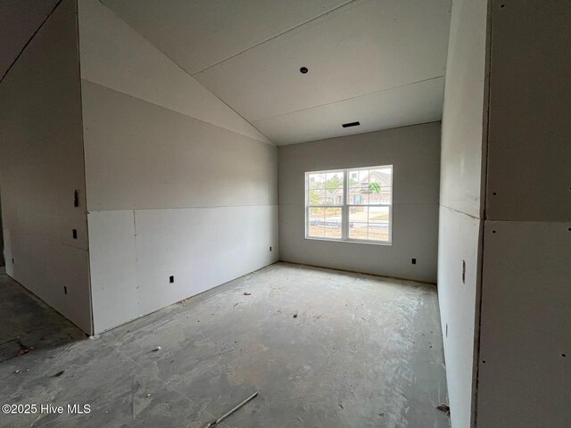 empty room featuring lofted ceiling