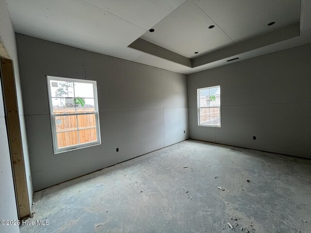 unfurnished room with a tray ceiling and visible vents