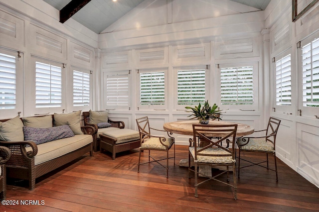 sunroom featuring vaulted ceiling with beams and a healthy amount of sunlight