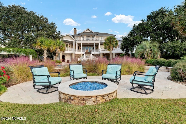 view of patio / terrace with a balcony and an outdoor fire pit