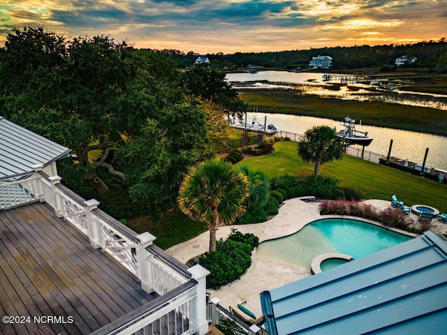 aerial view at dusk featuring a water view