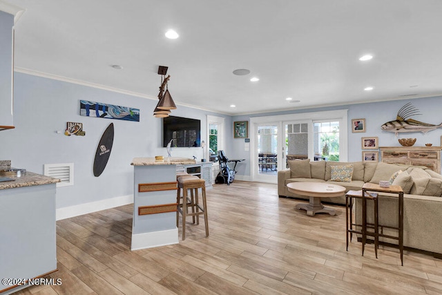 living room with light hardwood / wood-style flooring and ornamental molding