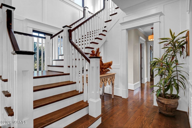 stairway with dark hardwood / wood-style floors