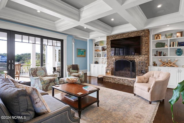 living room featuring dark hardwood / wood-style floors, french doors, built in features, coffered ceiling, and a stone fireplace