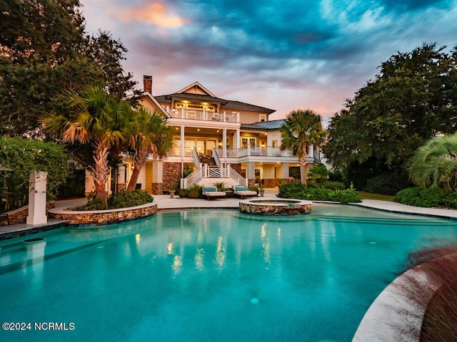 pool at dusk with a patio area