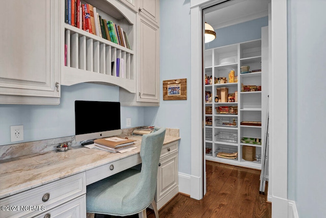 office area with built in desk and dark wood-type flooring