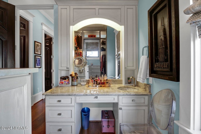 bathroom featuring hardwood / wood-style flooring, ornamental molding, and vanity