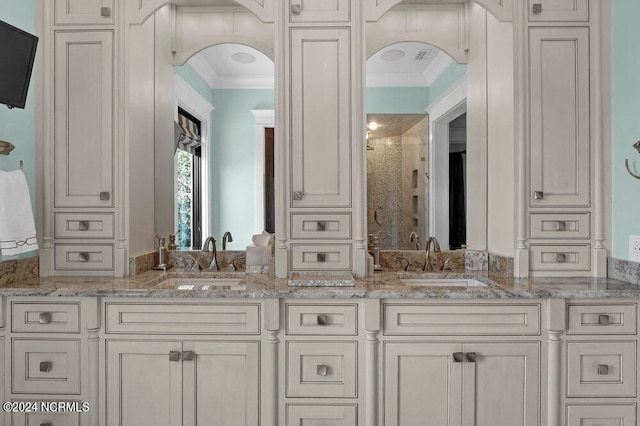 bathroom with ornamental molding and dual vanity