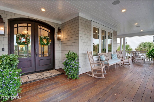 doorway to property featuring a porch and french doors