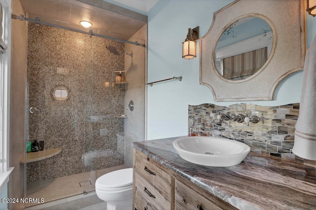 bathroom featuring vanity, toilet, tasteful backsplash, and walk in shower