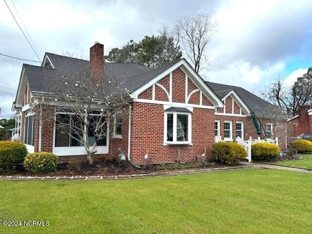 rear view of property featuring a lawn