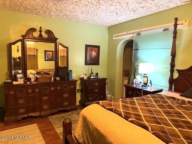 bedroom with dark hardwood / wood-style flooring and a textured ceiling