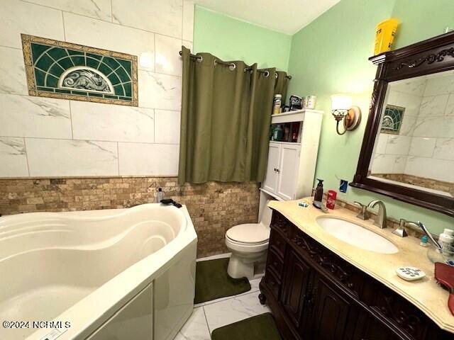 bathroom featuring toilet, large vanity, tile walls, tile floors, and a tub