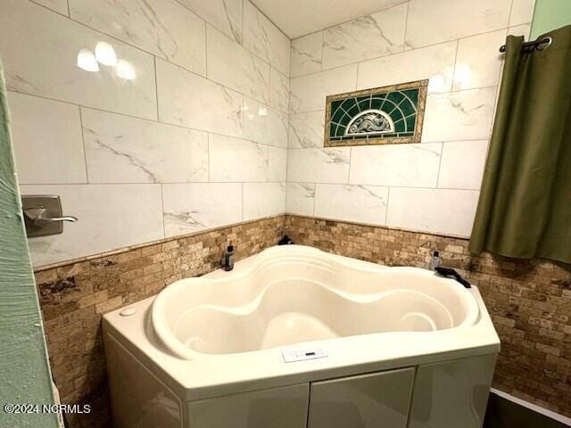 bathroom with tile walls and a bathing tub