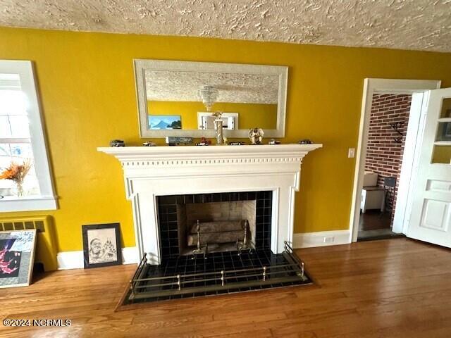 room details featuring a fireplace, a textured ceiling, and hardwood / wood-style floors