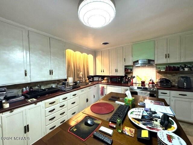 kitchen with range, backsplash, white cabinetry, dishwasher, and wall chimney range hood