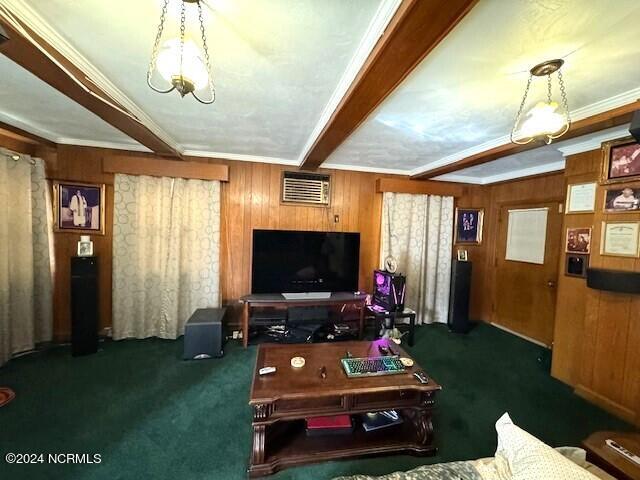 carpeted living room with ornamental molding, a chandelier, beam ceiling, and wooden walls